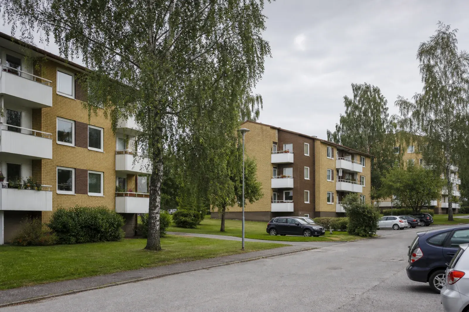 Flerfamiljshus i gult och brunt tegel med balkonger, bebyggelse av den typ som dominerar Geneta