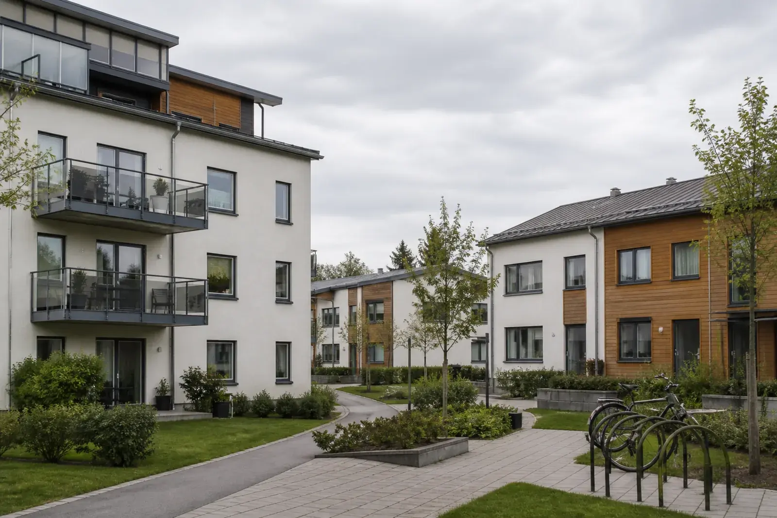 Nyare bostadshus med puts- och träfasader kring en gemensam gård, typiskt för modernare bebyggelse i Södertälje