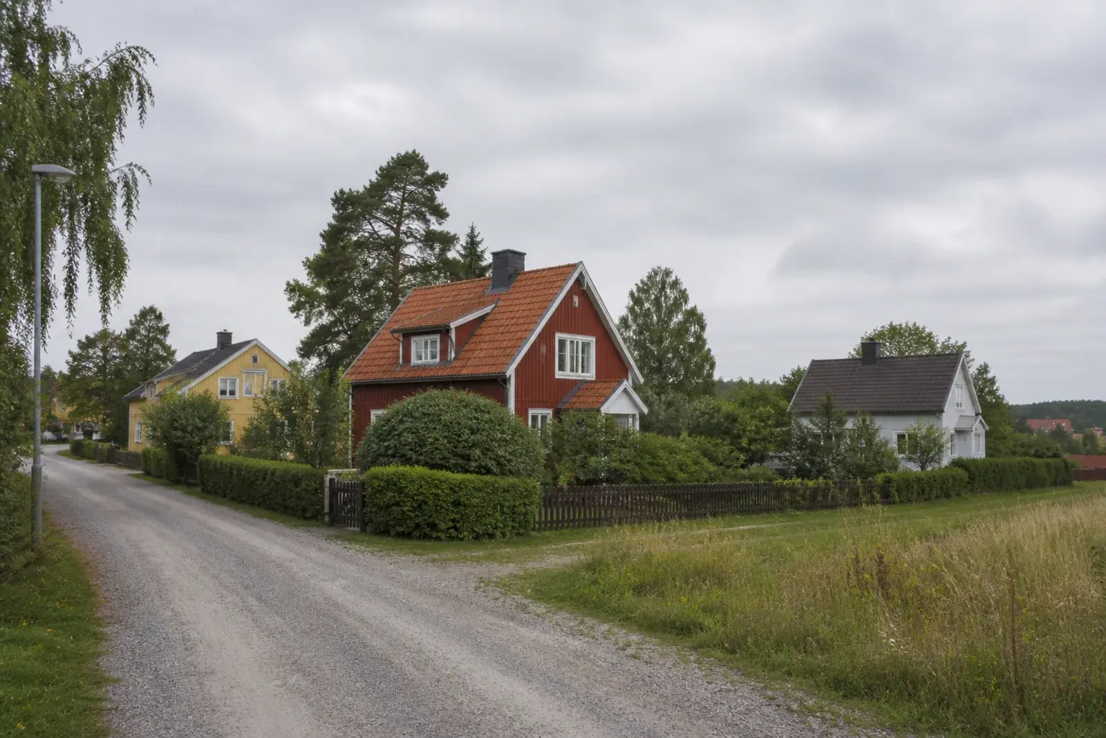 Trähus på stora tomter i utkanten av öppet landskap, typiskt för den lantliga bebyggelsen kring Pershagen
